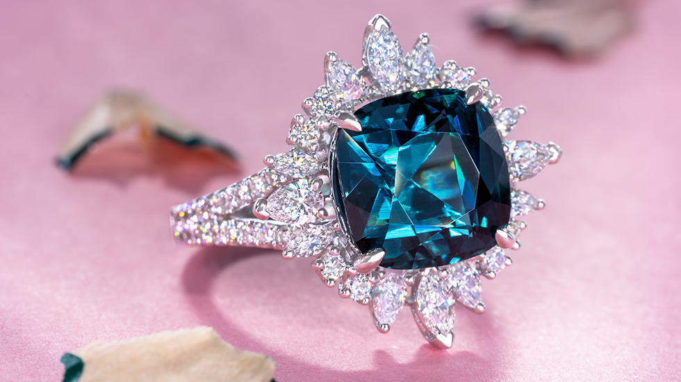 Cushion-cut dark blue indicolite tourmaline gemstone ring with a captivating starburst halo and a diamond-studded pave band.