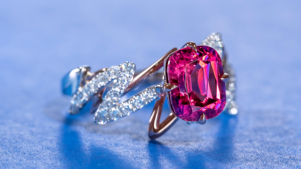 Close-up of a captivating hot pink spinel ring, crafted with intricate details that mimic the rhythm of a heartbeat. The vibrant pink gemstone takes centrestage, reflecting light with its brilliant facets. The delicate band features sharp curves, complementing the ring's edgy design.