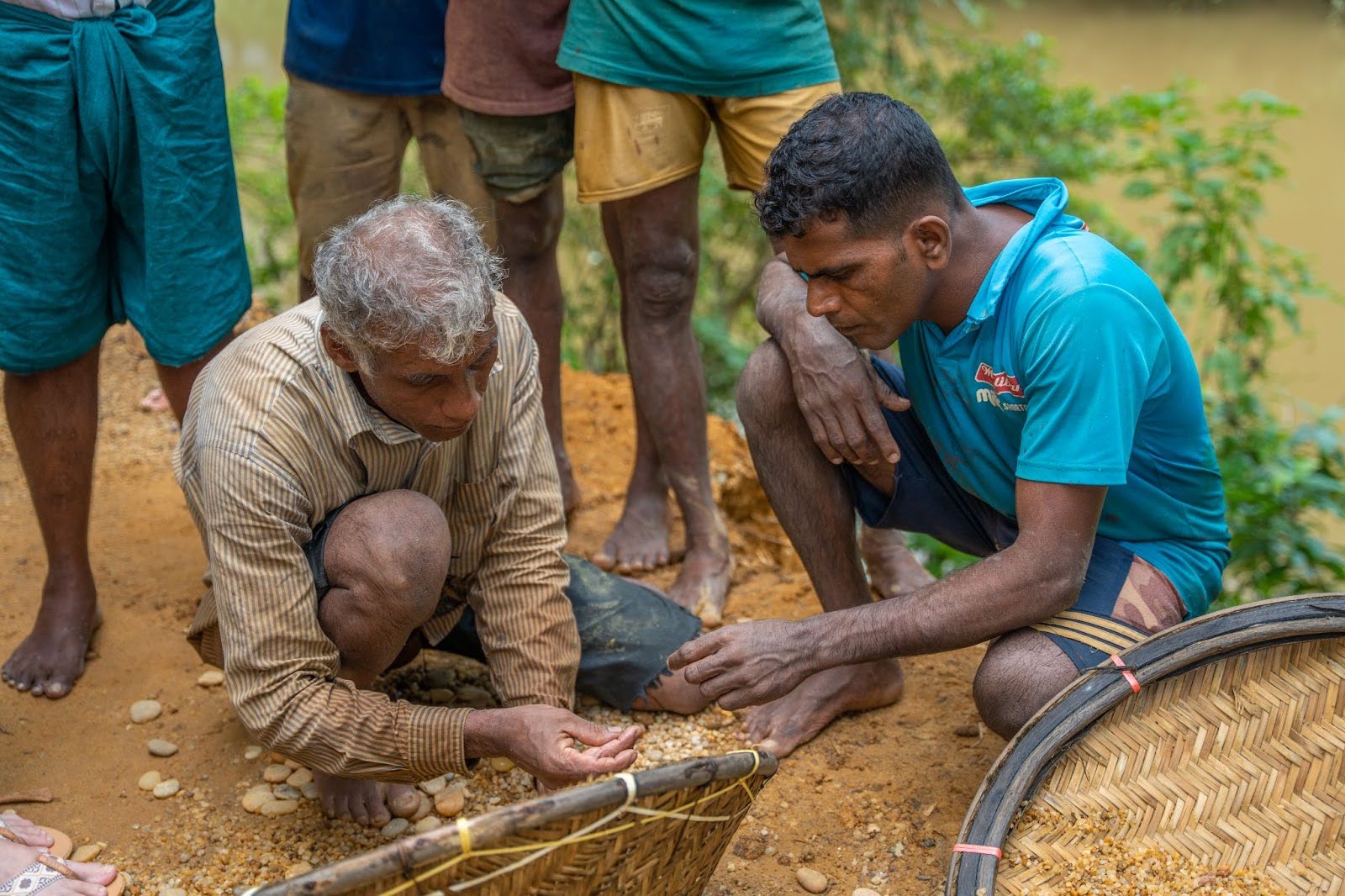 Miners in Sri Lanka carefully inspecting sifted gem-bearing gravel, known as illam, from pits after thorough washing