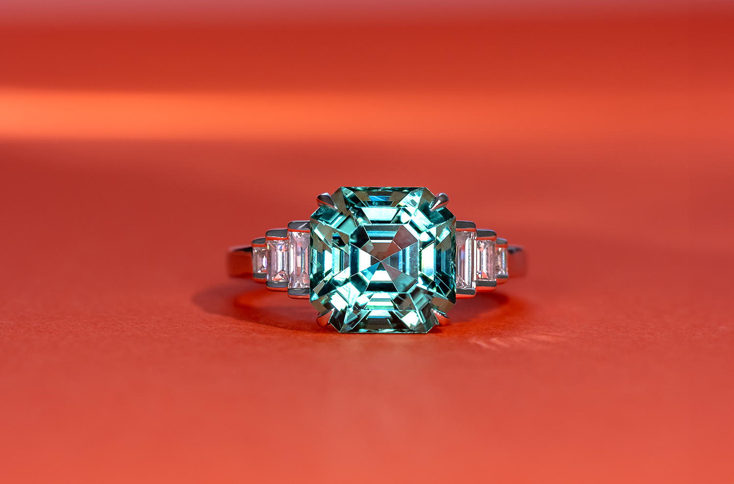 An elegant step-cut Tourmaline ring with baguette diamonds flanking the main stone emphasising its size and colour.