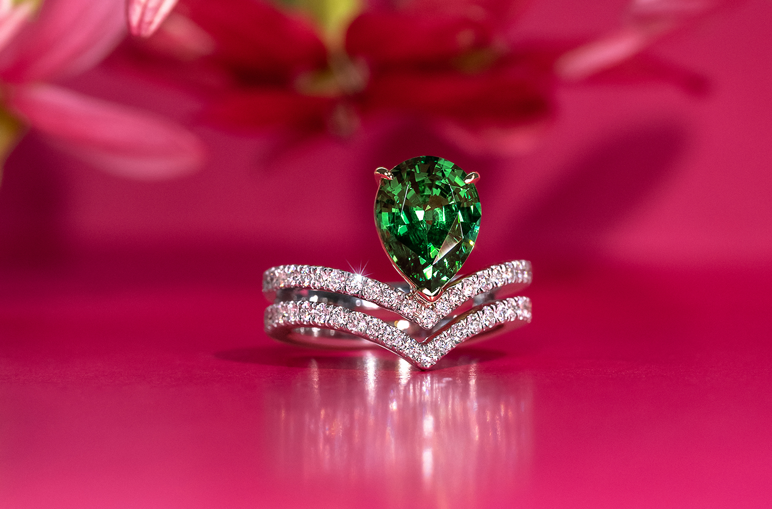 A stunning green Tsavorite ring featuring a sparkling diamond bands, showcasing elegance and luxury in design.